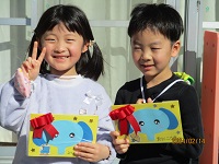 5歳児ぞう組の誕生児が誕生カードをもらって笑顔の写真