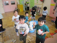 2歳児ぱんだ組の子どもたちがタライに雪を入れて、部屋で雪遊びをしている写真