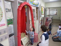 0歳児がしんさか神社でおみくじをひこうとしている写真です。