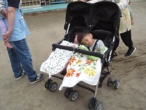 バギーに揺られて気持ちよさそうに眠る1歳児の写真