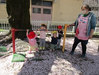 1歳児りす組が鉄棒で遊んでいる様子の写真