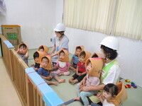 1歳児が防災頭巾を被っている様子の写真