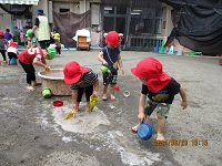 川を作って泥んこ遊びをしている写真です。