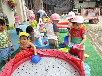 1歳児が水遊びをしている写真です。