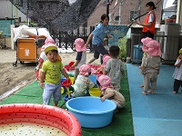 1歳児が水遊びをしている写真です。