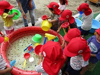 2歳児が水遊びしている写真です。