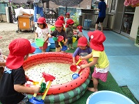 2歳児が水遊びしている写真です。