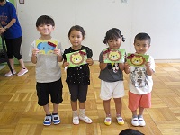 5歳児3歳児が誕生カードを見せている写真です。