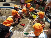 5歳児が泥んこ遊びをしている写真です。