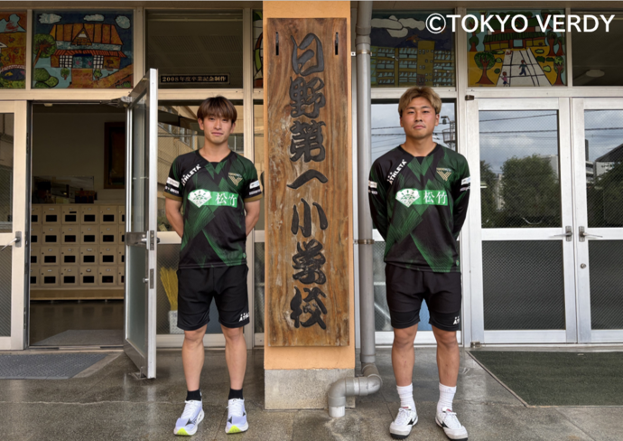 熊取谷選手と新井選手 学校の看板前での写真