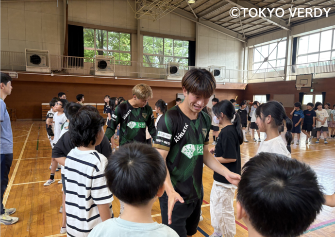 写真:選手が子どもたちとハイタッチをする様子
