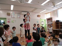 誕生児を歌でお祝いしている写真です。