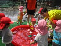 1歳児の水遊びをしている写真です。