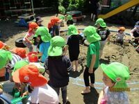 4歳児がどろんこ遊びをしている写真です。
