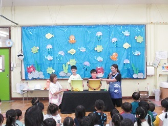 8月の誕生会で箱の中身はなんだろなクイズをしている様子の写真