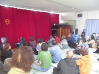 観客が大勢いて幕が下りている写真