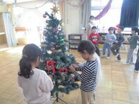 5歳児がツリーの飾りつけをしている写真