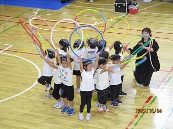 4歳児の子どもがフラフープを持ち、ダンスをしている様子の写真