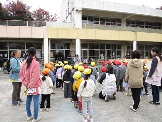 4歳児と5歳児の子ども達が第七幼稚園の園庭で集会をしている様子の写真