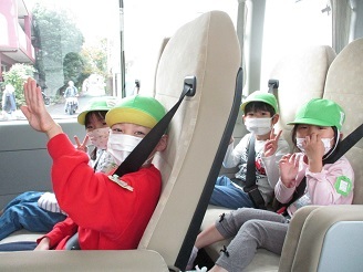 5歳児の子ども達がりんご狩りに行くため、バスに乗っている様子の写真