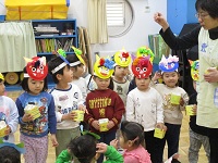 作ったお面をかぶって参加している3歳児の様子の写真