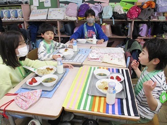 5歳児らいおん組が旭が丘小学校で給食体験をしている様子の写真