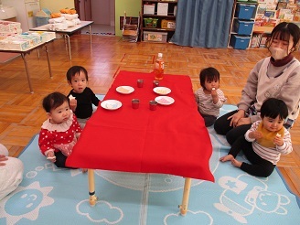 0歳児ひよこ組がお茶処でお菓子を食べている様子の写真