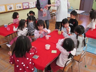 2歳児うさぎ組がお茶所でお菓子を食べている様子の写真