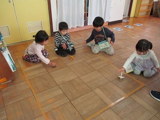 3歳児こあら組がコマであそぶ様子の写真