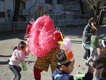 鬼に向かって豆を投げている様子。
