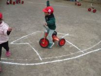 写真：三輪車にのる2歳児