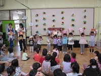 5月生まれの子どもが、誕生カードを上に掲げている様子