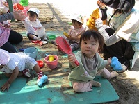 砂場遊びの0歳児の様子の写真