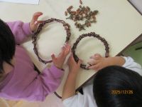 友だちと一緒にどんぐりのリースを作っている写真です。