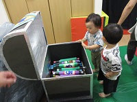 宝箱からお宝を見つけた子どもの様子の写真