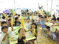 5歳児が向けたトウモロコシを手にしている様子の写真