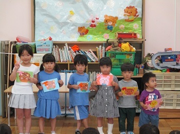 誕生児が誕生カードを持って並んでいる写真