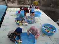 写真:3歳児が水遊びをしている様子