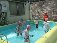 写真:4歳児がプールで流れるプール作りで走っている様子
