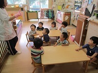 写真：1歳児が手袋人形を楽しんでいる様子