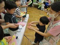 写真：誕生児に友達が誕生カードを渡している様子